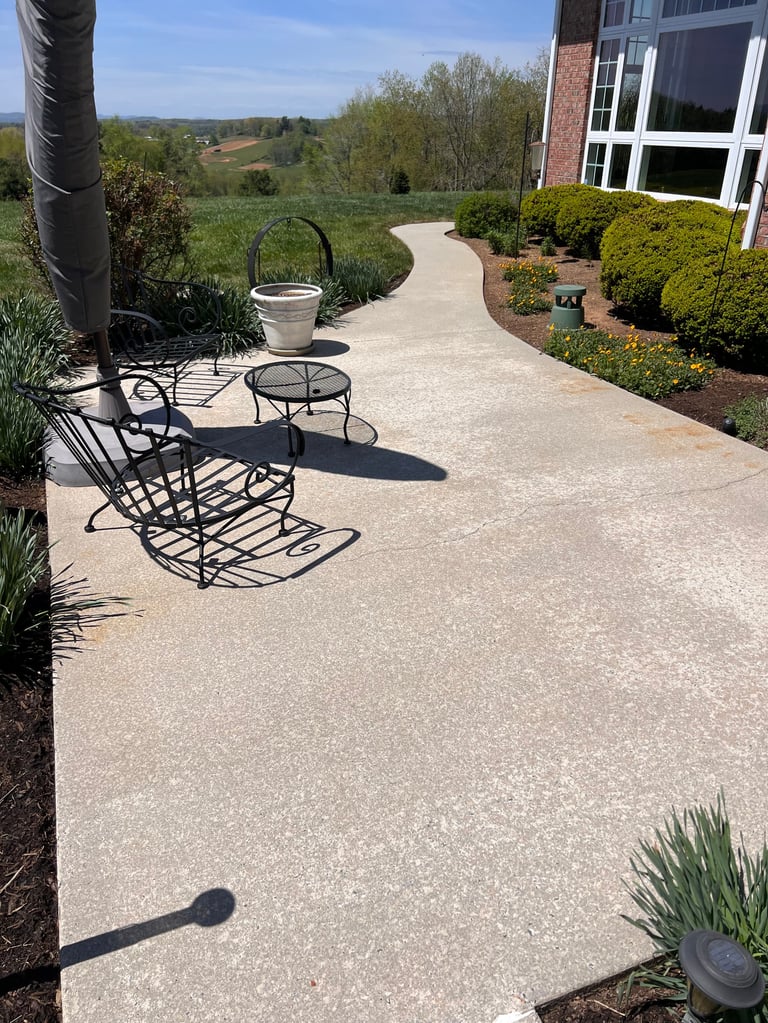 Patio seating area with metal chairs and table overlooking scenic countryside landscape